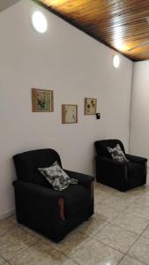 a living room with two black couches in a room at Magda in Resistencia