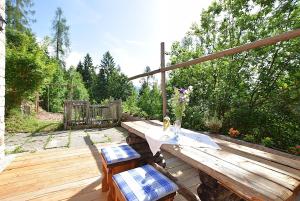 a wooden deck with a table and two chairs at Baita Costa Di Gial in Lamon +46 photos