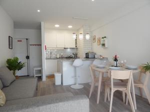 a living room and kitchen with a table and chairs at Casa Bella Arch, 2 min walk to beach Praia da Rocha in Portimão