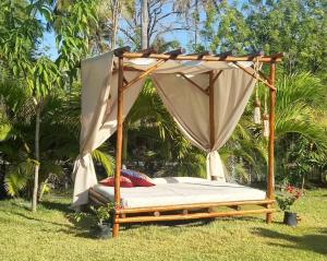 a canopy bed in the grass in a yard at Casa di Palmas in Pecém