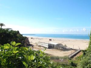 a view of a beach with a building and the ocean at Casa Bella Arch, 2 min walk to beach Praia da Rocha in Portimão
