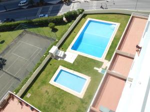 an overhead view of two swimming pools on a tennis court at Casa Bella Arch, 2 min walk to beach Praia da Rocha in Portimão
