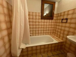 a bathroom with a tub and a sink and a mirror at Chalet Le Refuge in Samoëns
