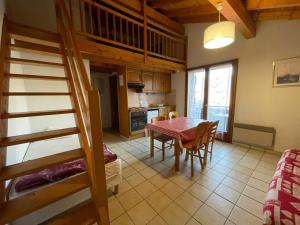 a kitchen and dining room with a table and a bunk bed at Chalet Le Refuge in Samoëns +23 photos