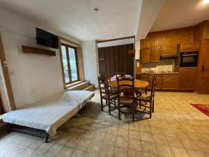 a room with a bed and a table and chairs at Chalet Le Refuge in Samoëns