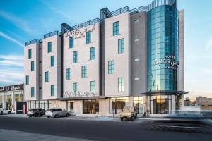 a large building with cars parked in front of it at Ayas Hail Hotel - فندق أياس حائل in Hail