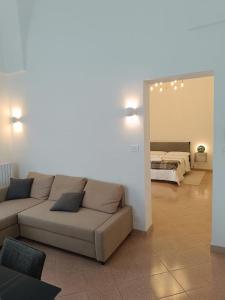 a living room with a couch and a bedroom at Dimora Novecento Lecce in Lecce