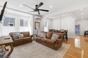 a living room with two couches and a ceiling fan at Historic home on Salem Neck in Salem