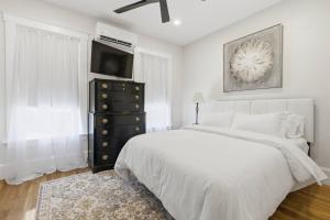 a bedroom with a bed and a dresser with a television at Historic home on Salem Neck in Salem