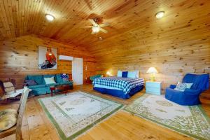 a room with a bed and a couch in a log cabin at Leavitt Bay Shores in Ossipee
