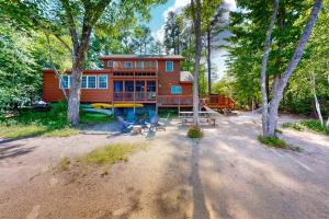 a cabin in the woods with chairs and trees at Leavitt Bay Shores in Ossipee