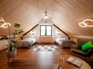 a room with three beds in a attic at Osada Puszczy Śpiew in Grotów