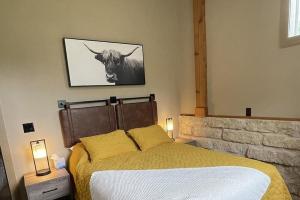 a bedroom with a bed and a picture of a cow at Buda Casita in Buda