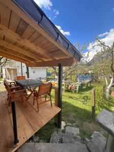 a wooden deck with a table and chairs under a roof at Guest House GURI in Vusanje