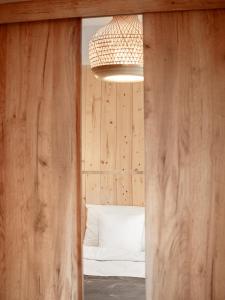 a room with a bed with a wooden wall at Osada Puszczy Śpiew in Grotów +123 photos