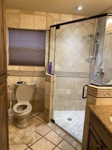 a bathroom with a toilet and a glass shower at Buda Casita in Buda +17 photos