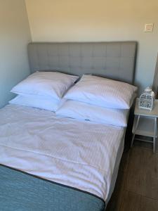 a large bed with white sheets and pillows at Lazurowy Zakątek in Dąbki