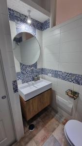 a bathroom with a sink and a mirror and a toilet at DIMORA REALE - Charming House Caserta in Casagiove