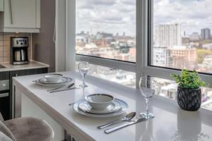 a kitchen with a table with plates and wine glasses at CN Tower Views - 2BR Condo - Balcony - Fast Wi-Fi in Toronto