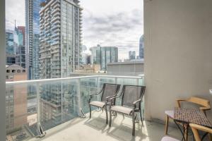 two chairs on a balcony with a view of a city at CN Tower Views - 2BR Condo - Balcony - Fast Wi-Fi in Toronto