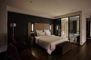 a hotel room with a large bed and a chair at 11 Mirrors Design Hotel in Kyiv +110 photos