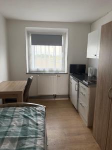 a small kitchen with a table and a window at Gasthaus Bikertreff in Gablingen