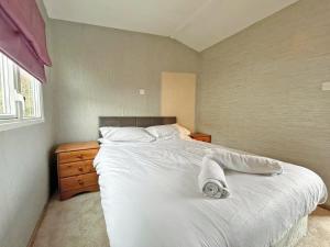 a bedroom with a large bed with white sheets and pillows at Brechin Getaway the rowan 2 bedroom static in Angus