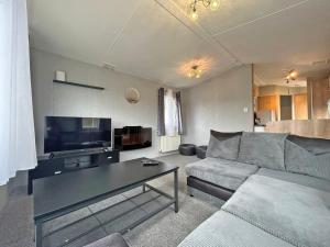 a living room with a couch and a table at Brechin Getaway the rowan 2 bedroom static in Angus