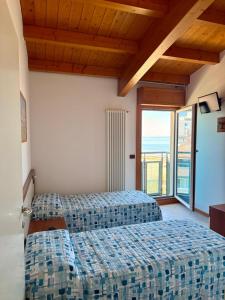 a bedroom with two beds and a large window at Monaco Apartments in Lignano Sabbiadoro +41 photos