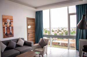 ein Wohnzimmer mit Sofa und großem Fenster in der Unterkunft Seen Ran Hotel Bouake in Bouaké