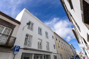 a white building with a parking sign in a street at Azor Signature Flats - I in Ponta Delgada