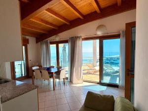 a kitchen and dining room with a view of the ocean at Monaco Apartments in Lignano Sabbiadoro