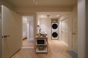 a kitchen with a stove and a washer and dryer at Covon Stay in Busan