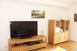 a living room with a flat screen tv and a wooden entertainment center at Ferienwohnung Kastanienblick in Uelzen