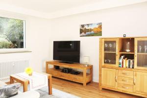 a living room with a tv and a wooden entertainment center at Ferienwohnung Kastanienblick in Uelzen