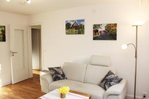 a living room with a couch and paintings on the wall at Ferienwohnung Kastanienblick in Uelzen +16 photos