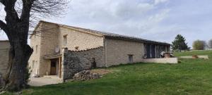 a stone building with a tree in front of it at Gite le pèlerin in Sault-de-Vaucluse