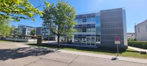a building with a tree in front of it at my MINGA Airport serviced Apartments in Hallbergmoos