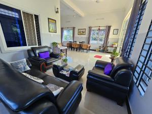 a living room with black leather furniture and a table at Anou Home - Guesthouse in Siem Reap