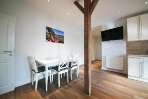 a kitchen and dining room with a white table and chairs at Ferienwohnung BEA 3 in Rabenkirchen-Faulück