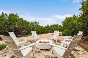 a group of white chairs sitting around a fire pit at Camp Jackalope - Outdoor Trails - Fire Pit - Views in Wimberley
