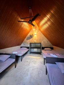 a room with two beds and a ceiling fan at Riverston Basecamp in Meda-Ela