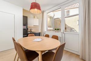 a dining room with a table and chairs and a window at Huyze Aïda in Bruges