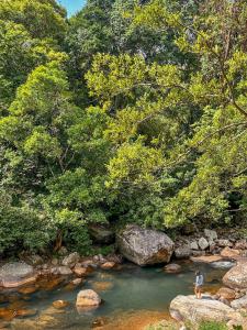 a man standing on a rock in a river at Riverston Basecamp in Meda-Ela