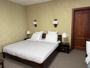 a bedroom with a bed with white sheets and pillows at Cмак бажання in Sebino