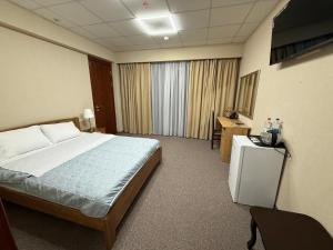 a hotel room with a large bed and a desk at Cмак бажання in Sebino