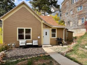 a small house with two chairs and a grill at The Miner's Getaway in Lead SD in Lead