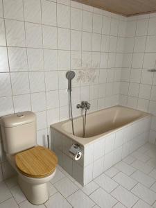 a bathroom with a toilet and a bath tub at Bergliebe in Weitnau