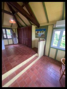 an attic room with a tiled floor and two windows at Les Nids Tropicaux in Marigot