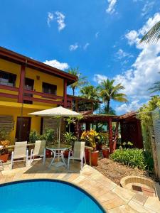 a resort with a swimming pool and a house at Residencial Villa Cris - Jd. São Lourenço/Itaguaré in Bertioga